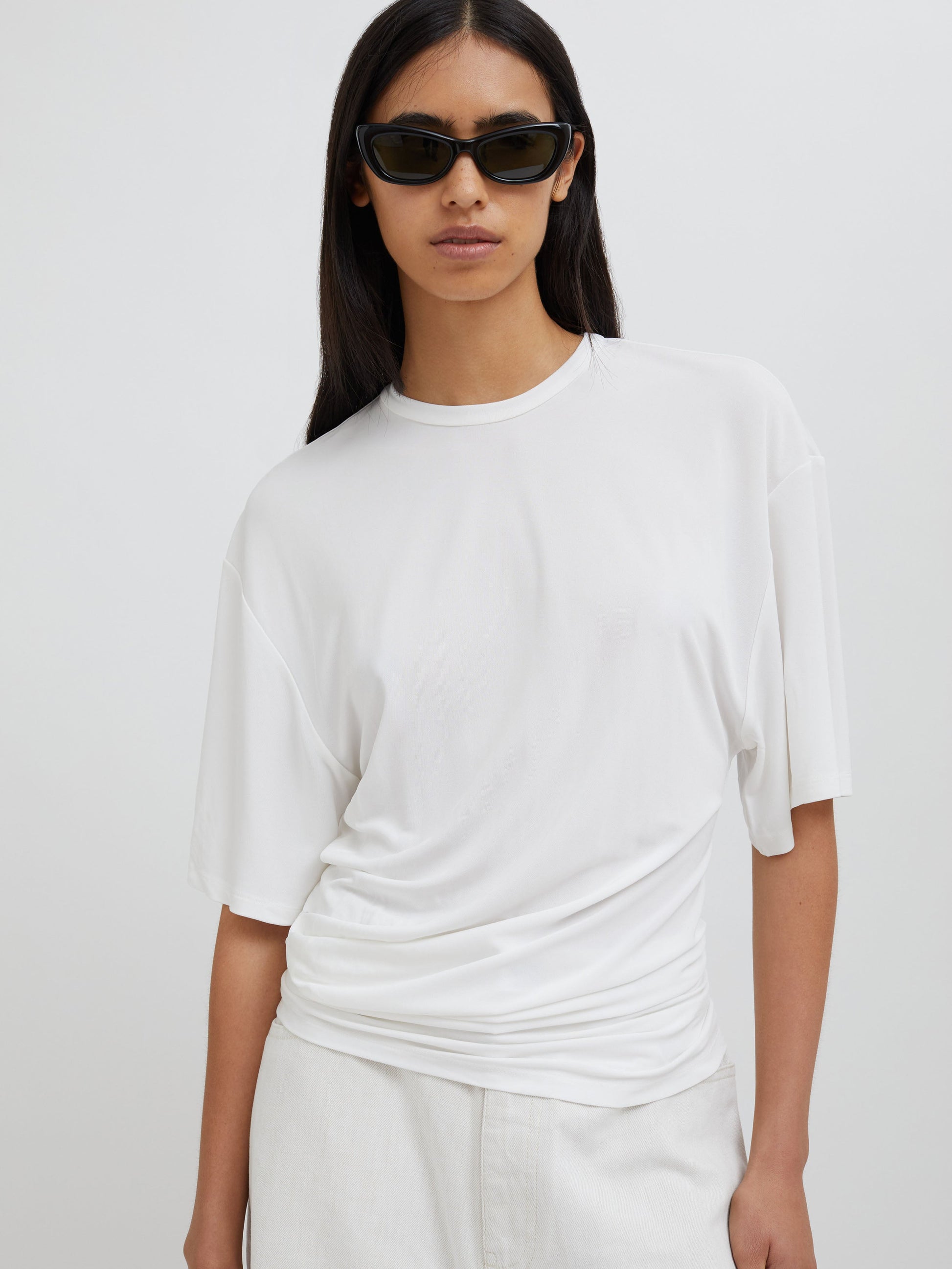 Image of a model wearing Tops. Productname: Christopher Esber Side Cowl Waist Tee in Milk colour by brand - Christopher Esber