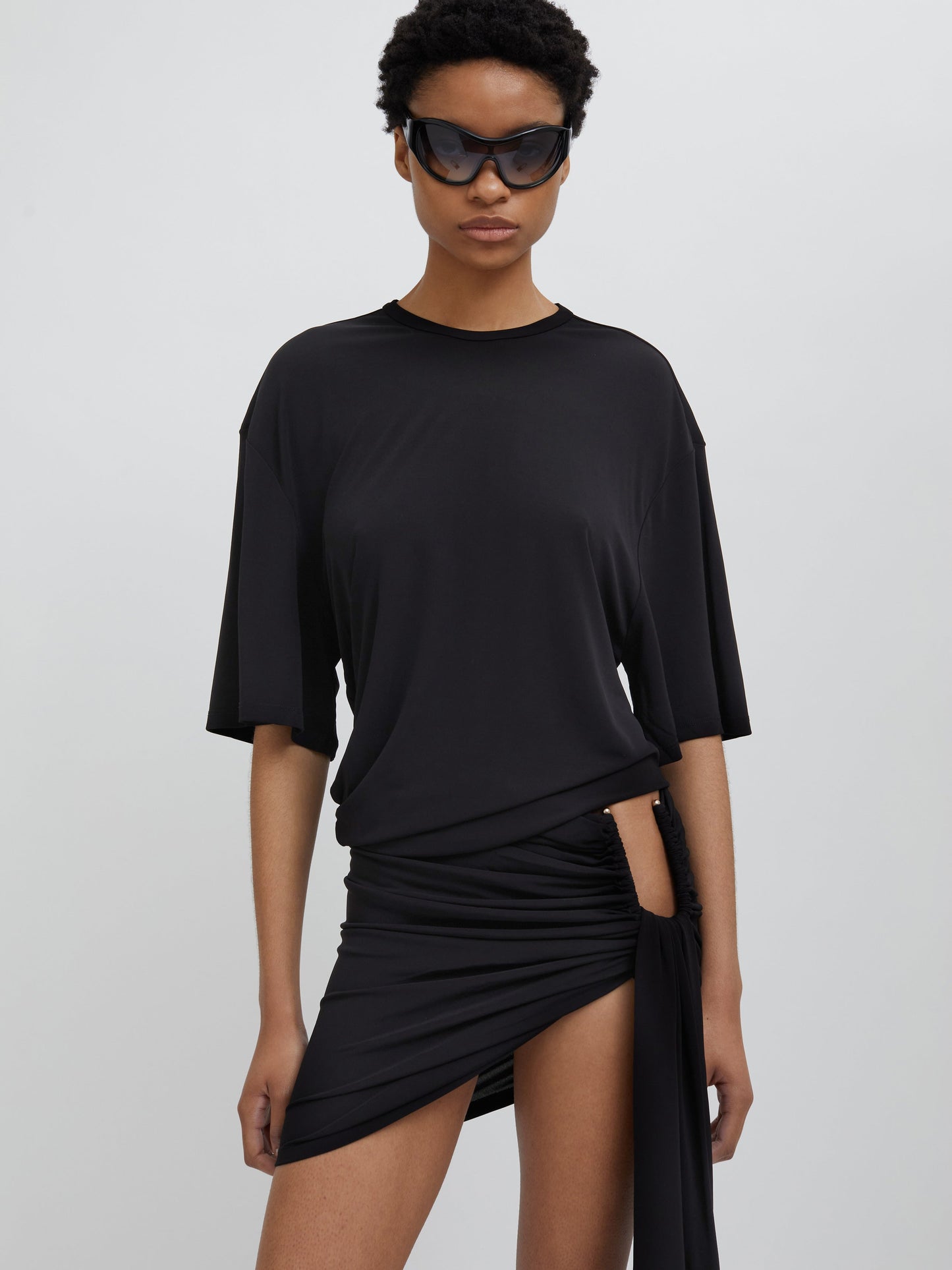 Image of a model wearing Tops. Productname: Christopher Esber Side Cowl Waist Tee in Black colour by brand - Christopher Esber