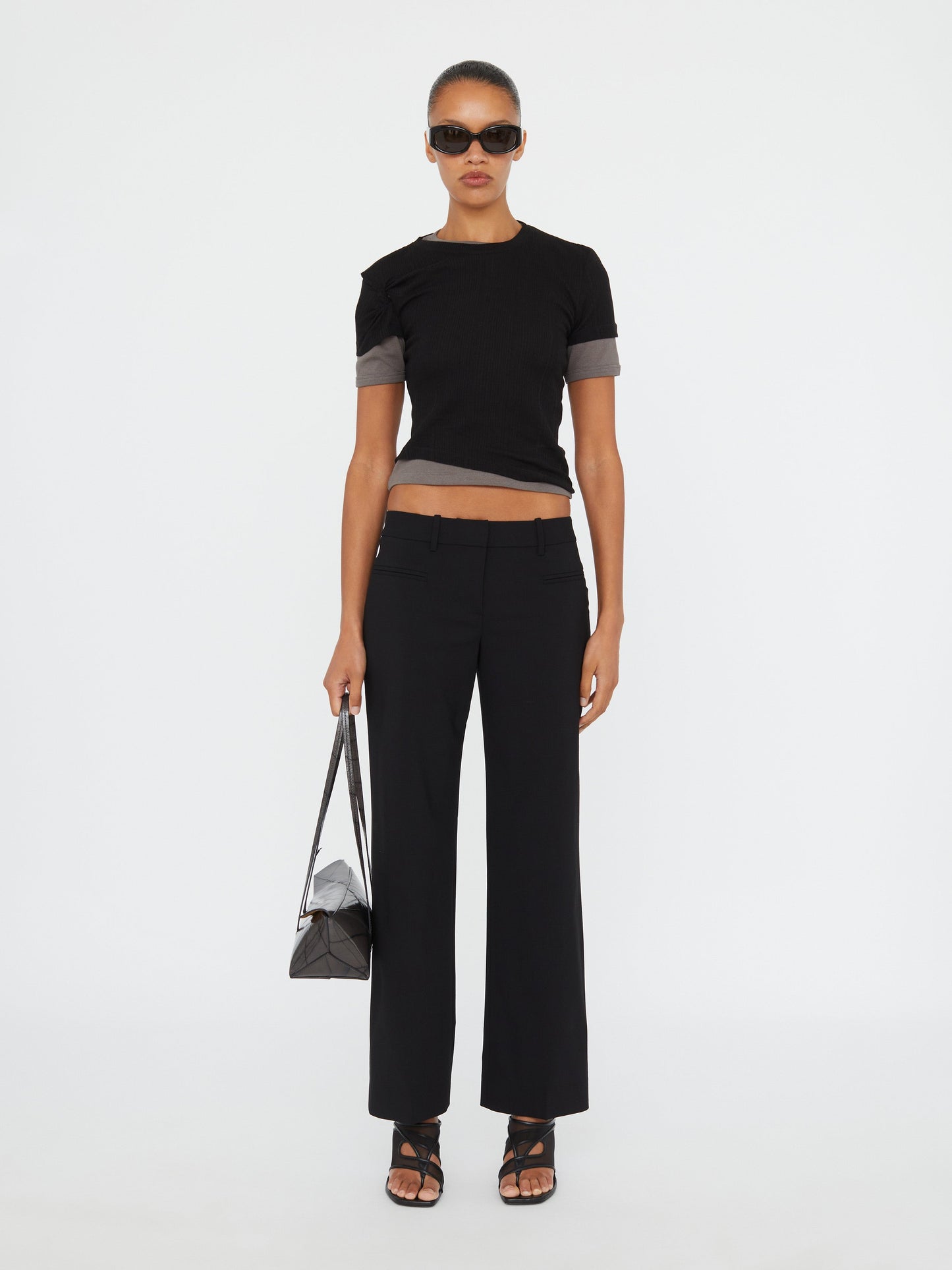 Image of a model wearing Pants. Product name - Double Fly Trouser in Black colour by brand - Christopher Esber