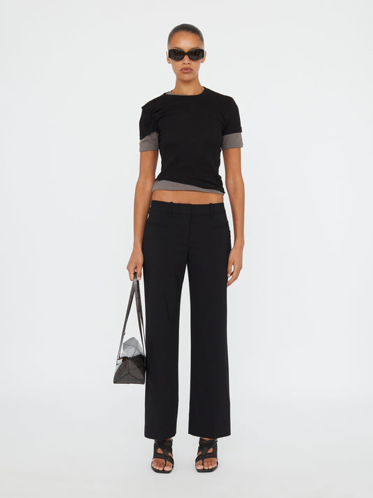 Image of a model wearing Pants. Product name - Double Fly Trouser in Black colour by brand - Christopher Esber