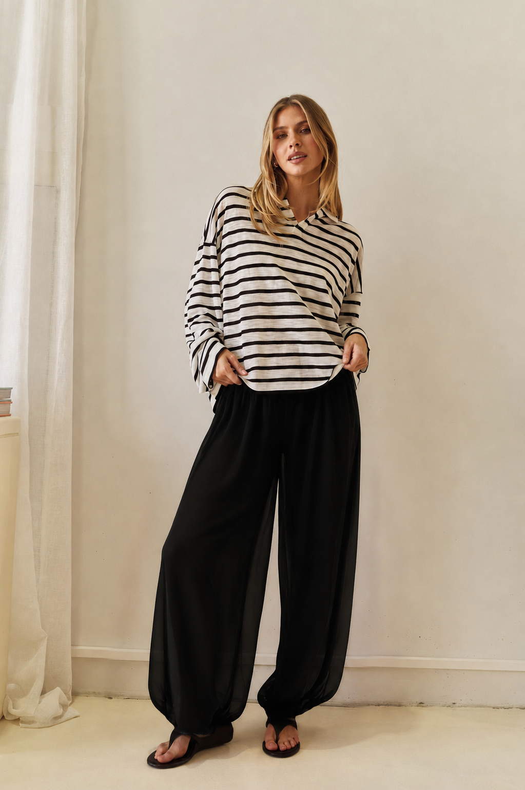 Image of a model wearing Pants. Product name - Miles Balloon Pant in Black colour by brand - Sass Clothing