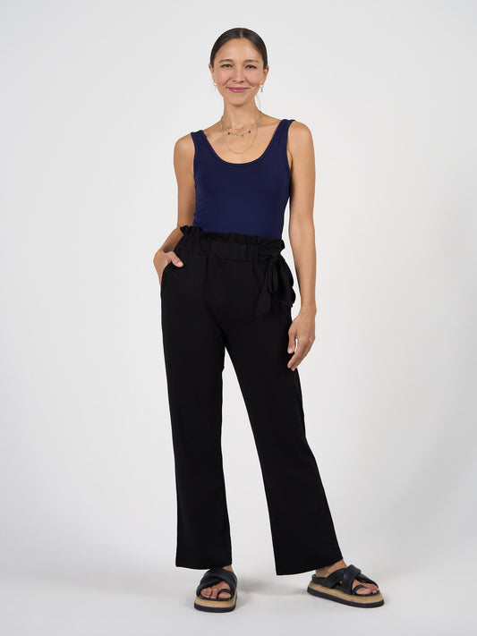 Image of a model wearing Pants. Product name - Tyler Bamboo Paperbag Pant in Black colour by brand - Lou Lou