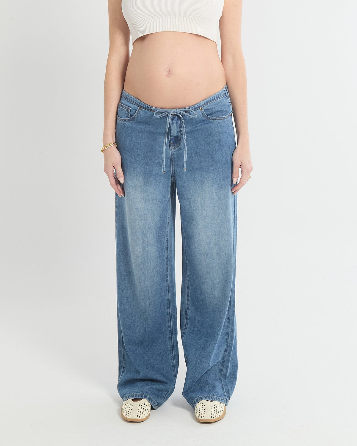 Image of a model wearing Pants. Product name - Relaxed Wide Leg Drawstring Jeans (draped) in colour by brand - Soon Maternity