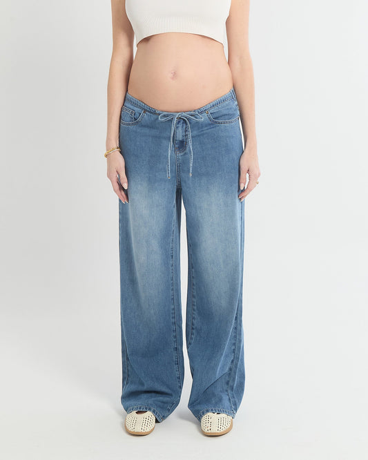 Image of a model wearing Pants. Product name - Relaxed Wide Leg Drawstring Jeans (draped) in colour by brand - Soon Maternity