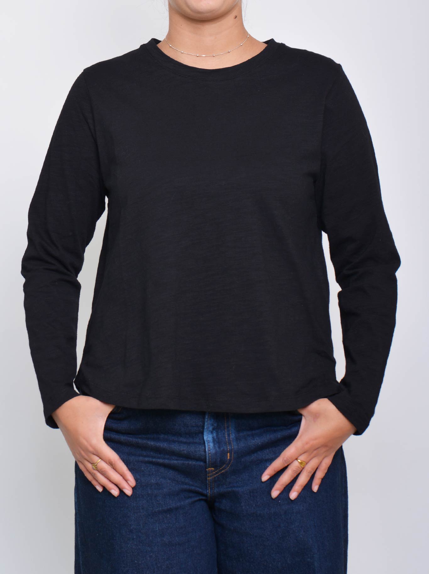 Image of a model wearing Tops. Product name - Enni Long Sleeve Tee in Black colour by brand - Enni