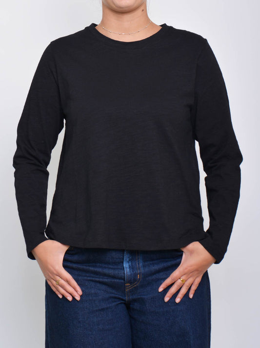 Image of a model wearing Tops. Product name - Enni Long Sleeve Tee in Black colour by brand - Enni