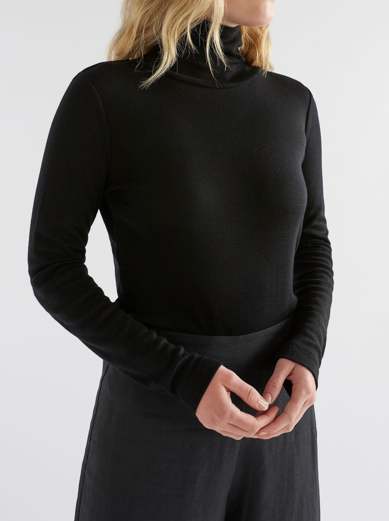 Image of a model wearing Tops. Productname: ELK MERINO LONG SLEEVE SKIVVY in Black colour by brand - Elk