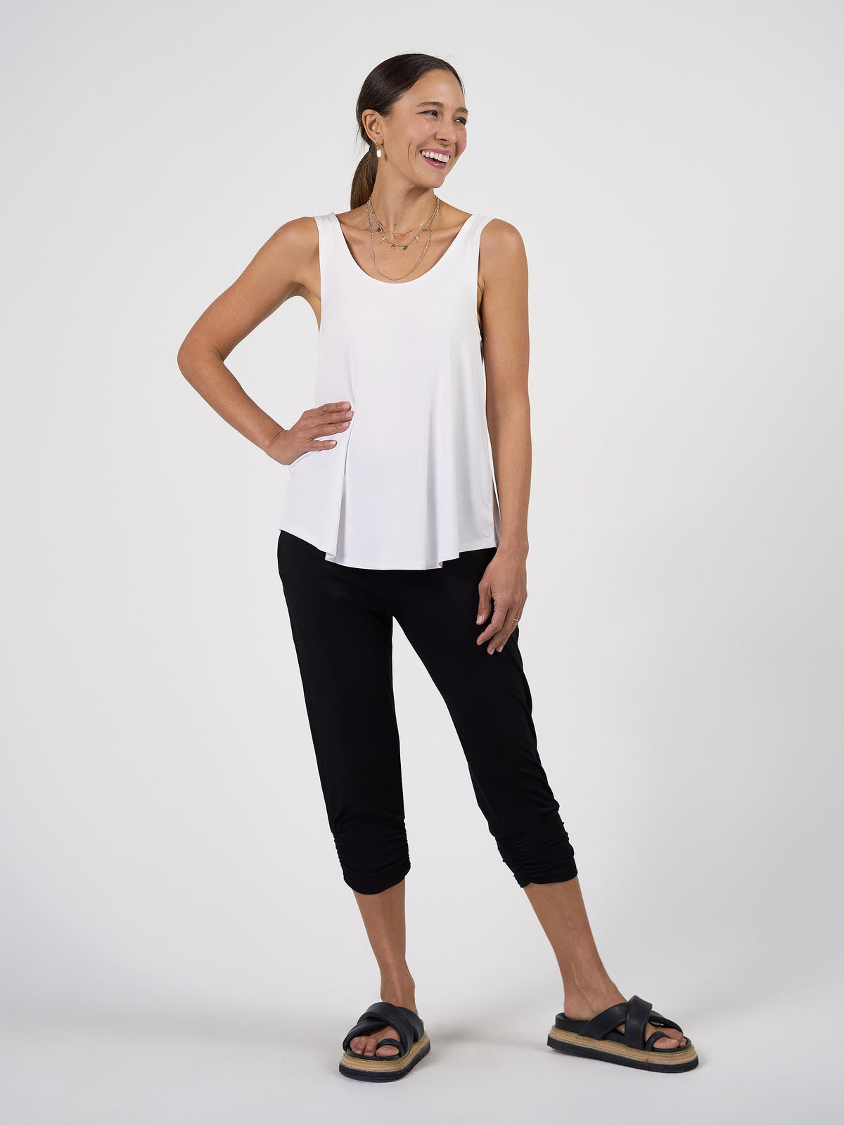 Image of a model wearing Tops. Product name - Ellie Sleeveless Bamboo Singlet Top White in White colour by brand - Lou Lou