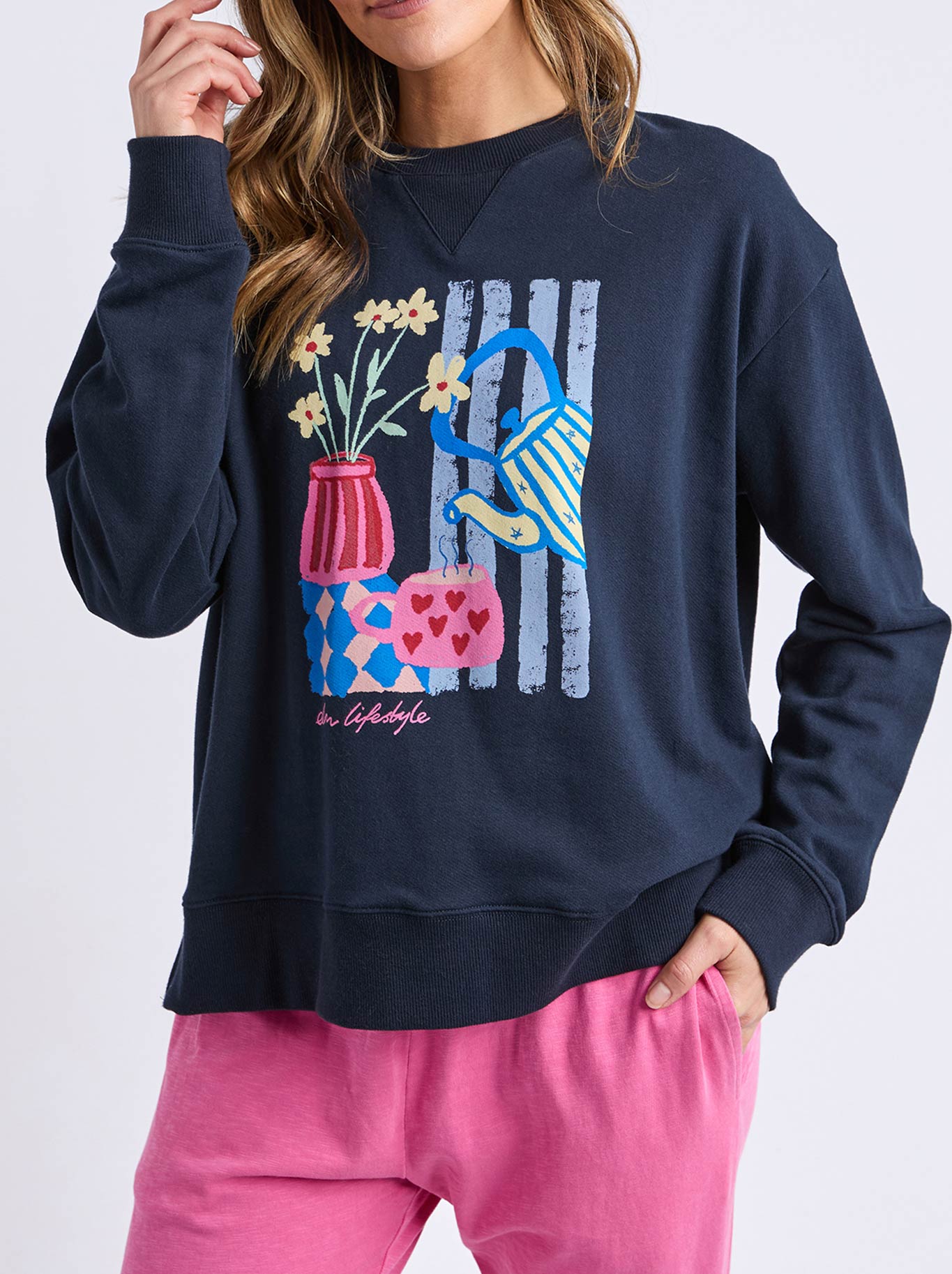 Image of a model wearing Tops. Product name - Elm Fill Your Cup Crew in Navy A colour by brand - Elm