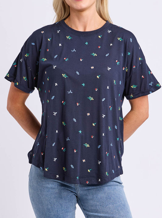Image of a model wearing Tops. Product name - ELM FESTIVE MARKET TEE in Navy colour by brand - Elm
