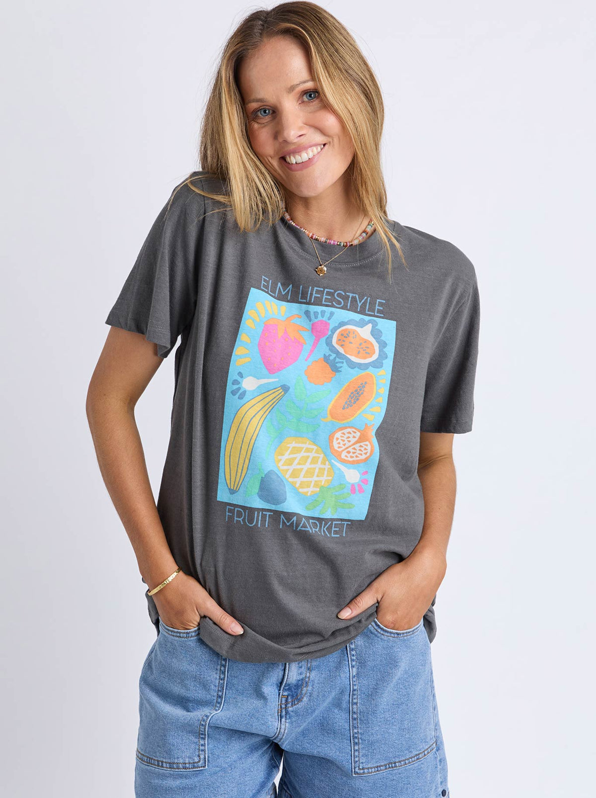 Image of a model wearing Tops. Product name - Elm Fruit Market Tee in Charcoal colour by brand - Elm