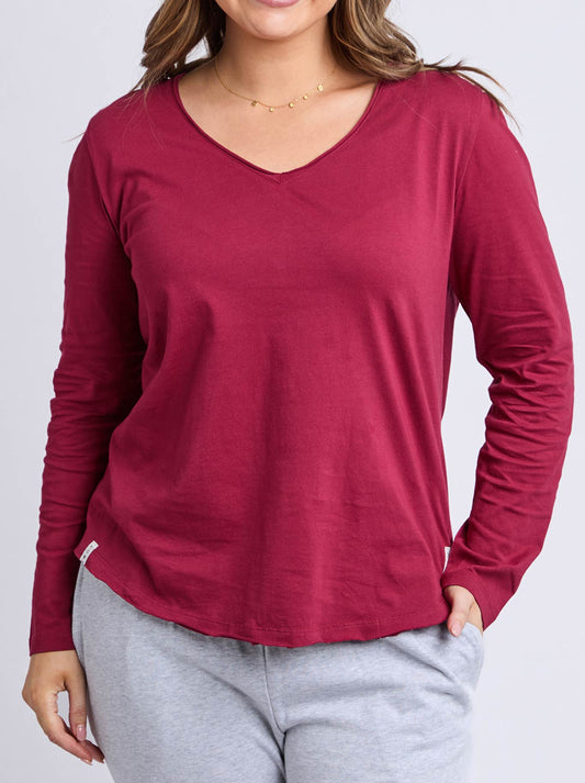 Image of a model wearing Tops. Product name - Elm Pima Long Sleeve Vee Tee in Maroon colour by brand - Elm