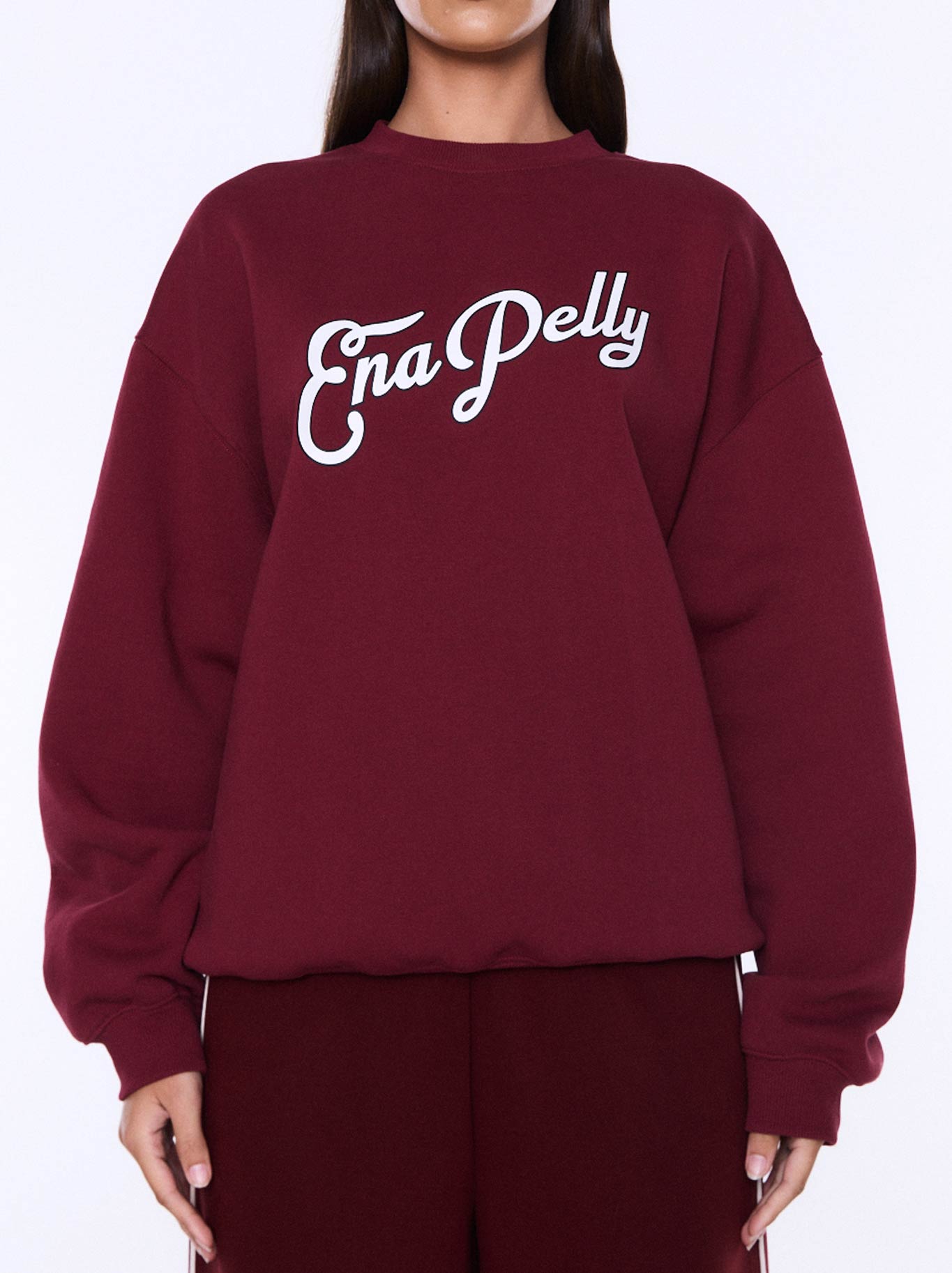 Image of a model wearing Tops. Product name - ENA PELLY MILA OVERSIZE SWEAT in Burgundy colour by brand - Ena Pelly
