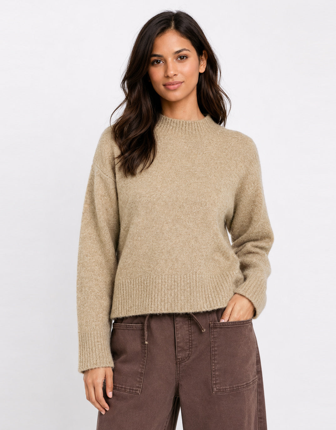 Image of a model wearing Outerwear. Product name - Forage Mock Neck Long Sleeve Jumper Biscuit in Biscuit colour by brand - Stories Be Told