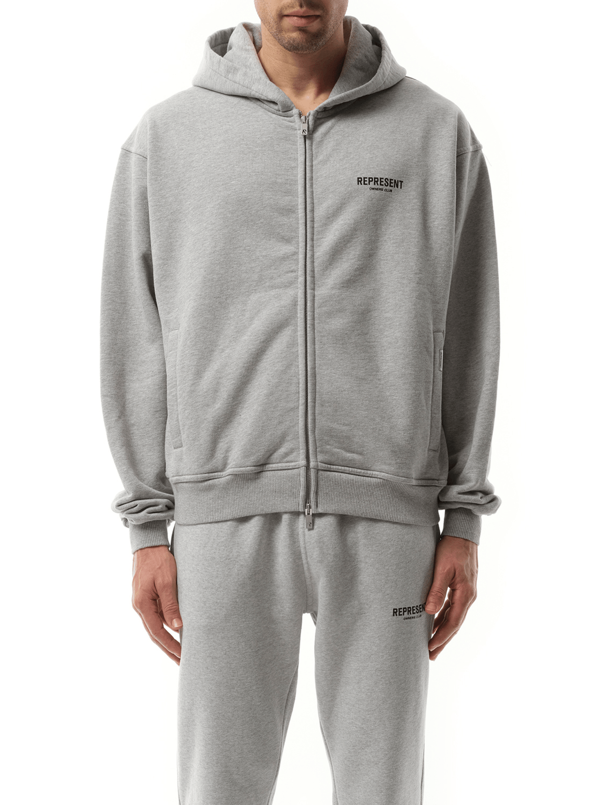 Image of a model wearing Outerwear. Product name - Represent Owners Club Zip Hoodie in Grey colour by brand - REPRESENT