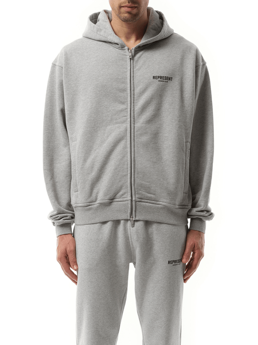 Image of a model wearing Outerwear. Product name - Represent Owners Club Zip Hoodie in Grey colour by brand - REPRESENT