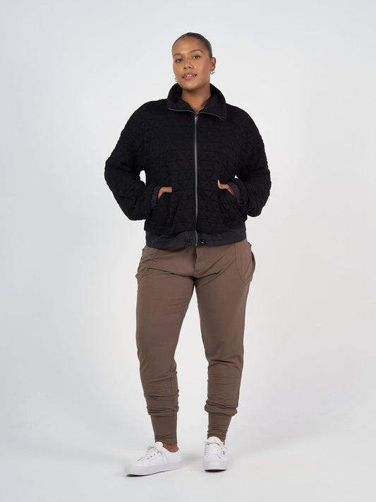 Image of a model wearing Pants. Product name - Gaga Bamboo Cuffed Sweat Pant Chocolate in Chocolate colour by brand - Lou Lou