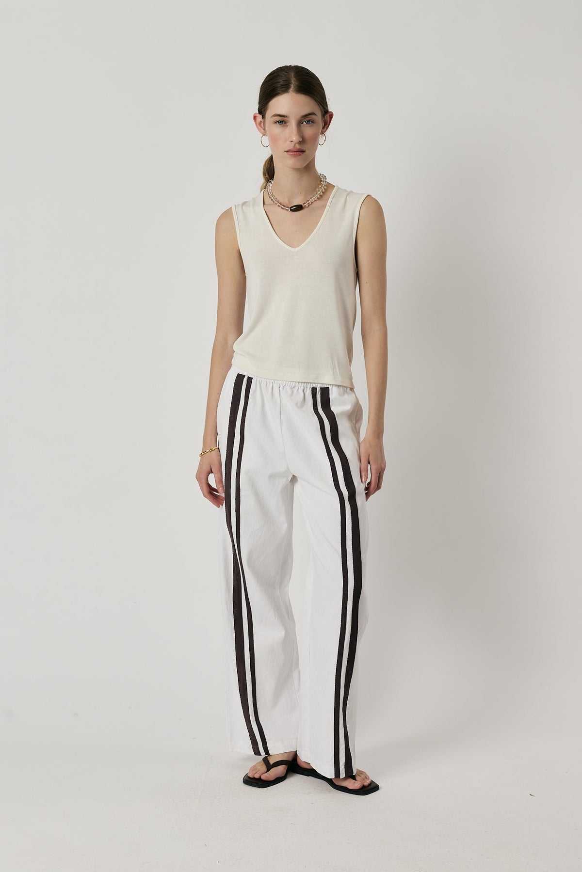 Image of a model wearing Pants. Product name - Giliann Adela Pant White in White colour by brand - Giliann