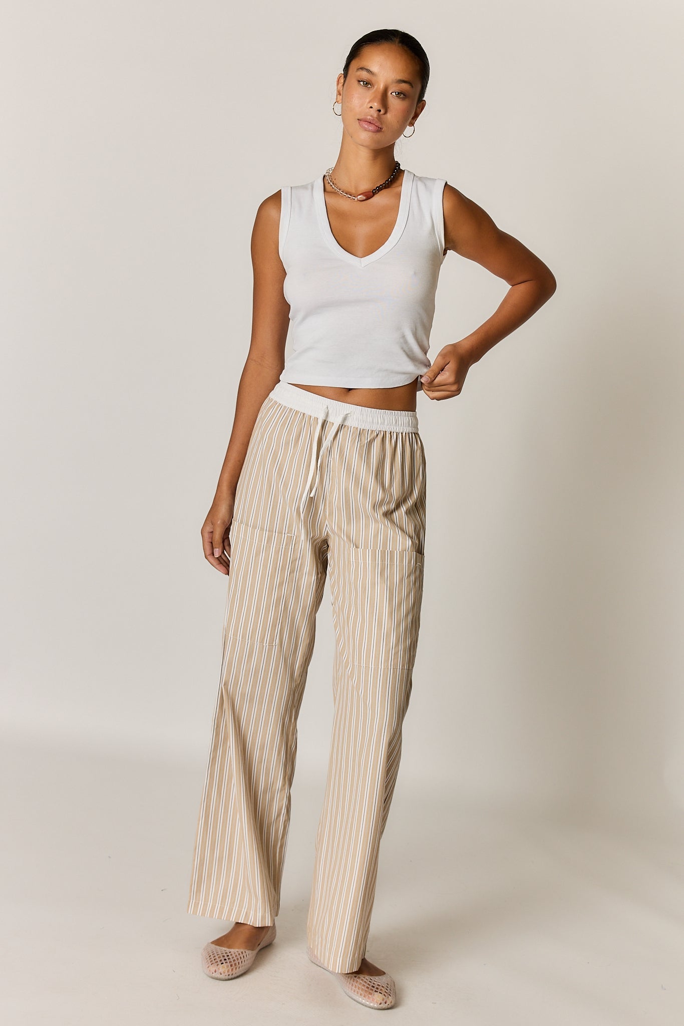 Image of a model wearing Pants. Product name - Giliann Alma Pocket Pant Tan Stripe in Tan colour by brand - Giliann