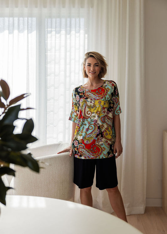 Image of a model wearing Tops. Product name - Gina Oversized Slouch Bamboo T-Shirt Noosa Pucci Print in Noosa Pucci colour by brand - Lou Lou