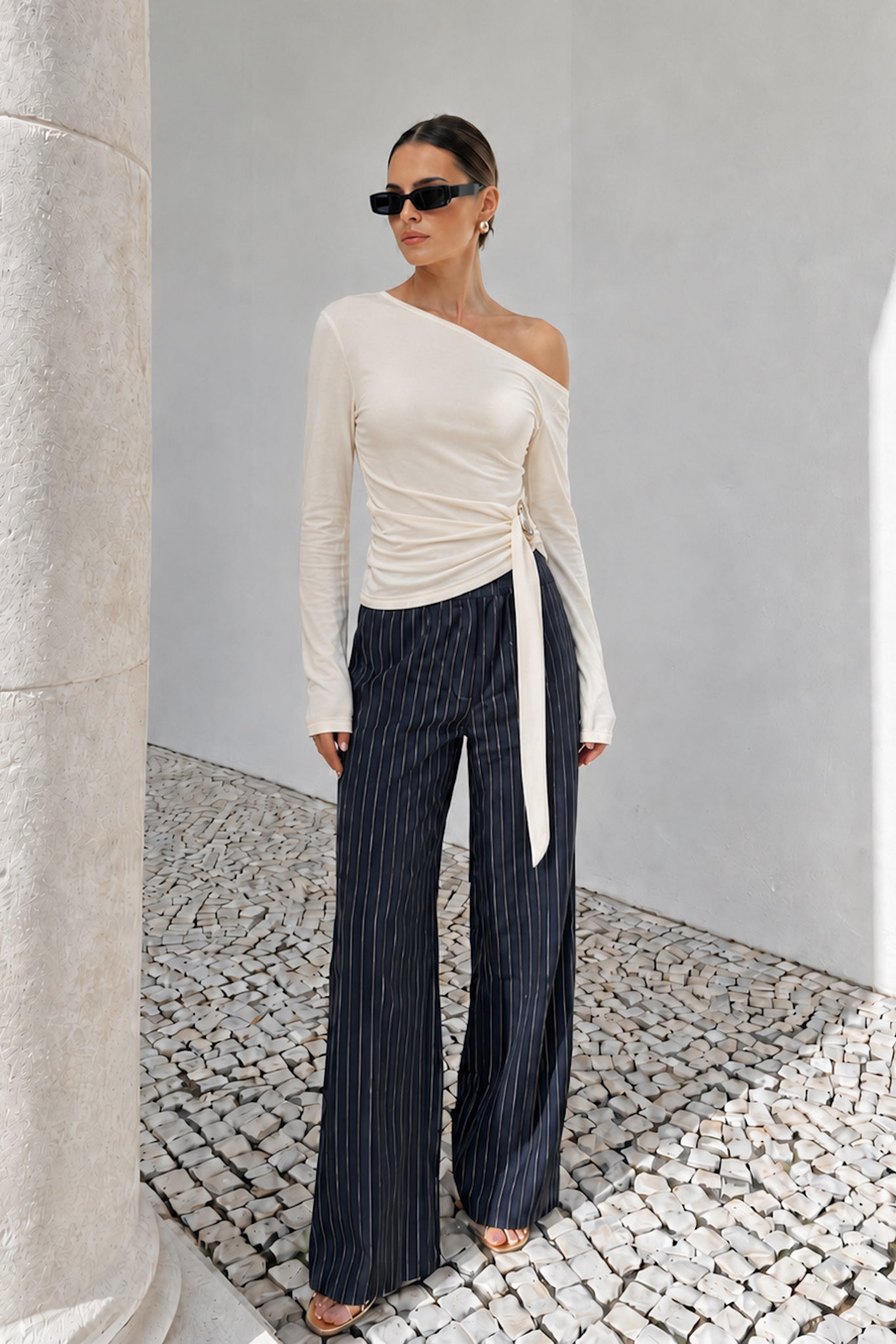 Image of a model wearing Tops. Product name - Jayn Beige Asymmetric Top in Beige colour by brand - HEYCHIC