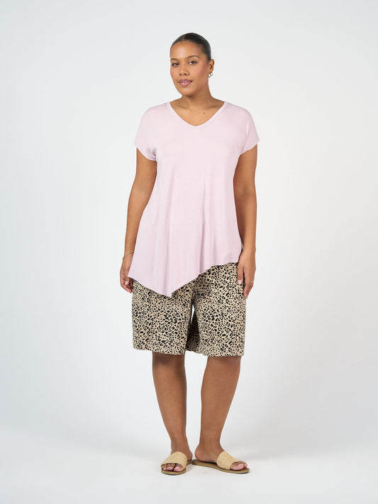 Image of a model wearing Tops. Product name - Holiday Asymmetrical Bamboo V-Neck T-Shirt Lilac in Lilac colour by brand - Lou Lou