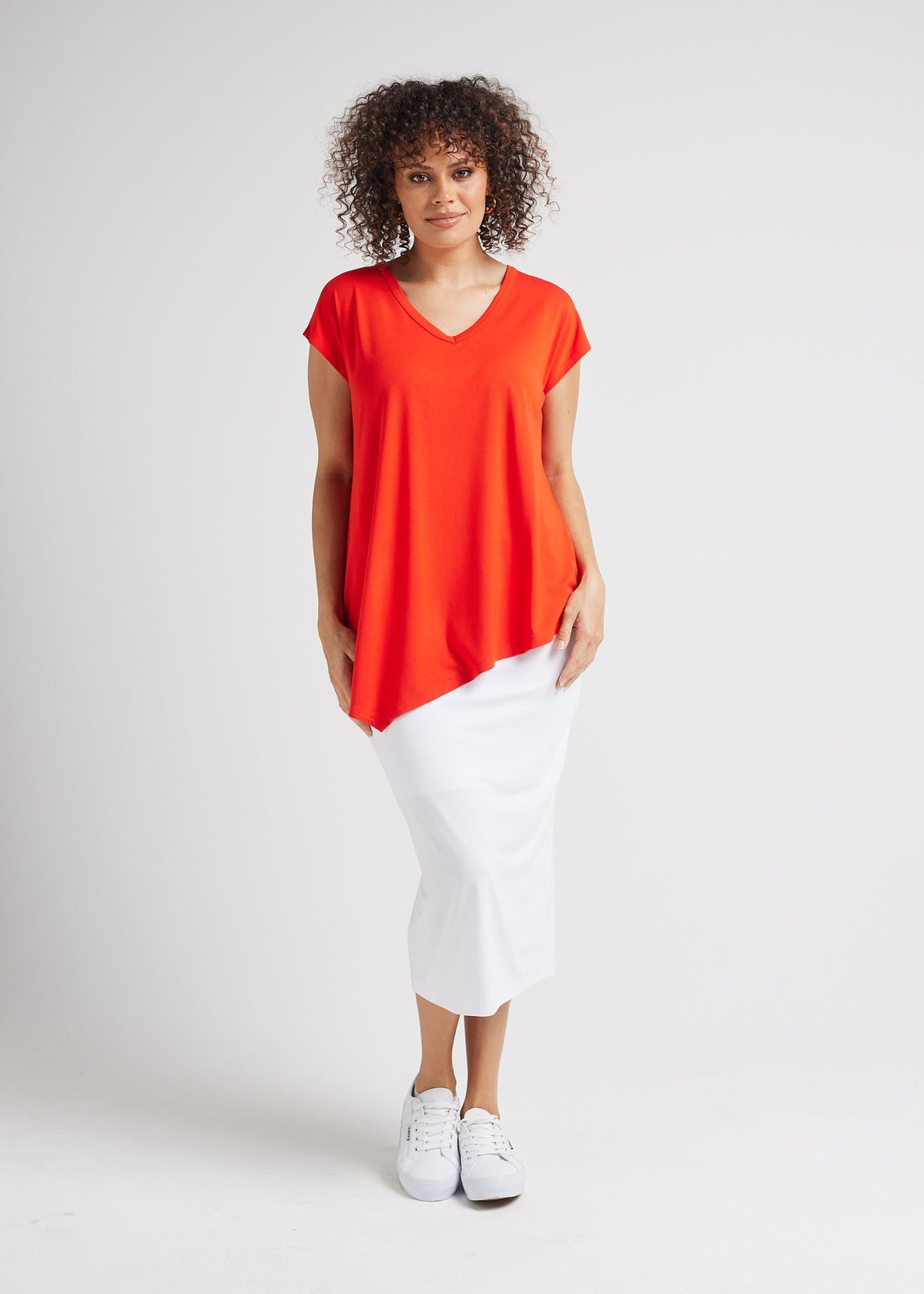 Image of a model wearing Tops. Product name - Holiday Asymmetrical Bamboo V-Neck T-Shirt in Fiery Red colour by brand - Lou Lou