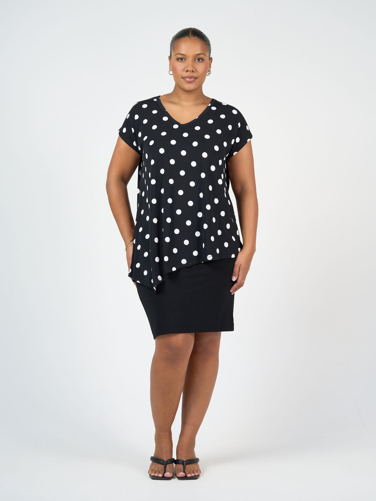 Image of a model wearing Tops. Product name - Holiday Asymmetrical Bamboo V-Neck T-Shirt Polka dot in Polka Dot colour by brand - Lou Lou