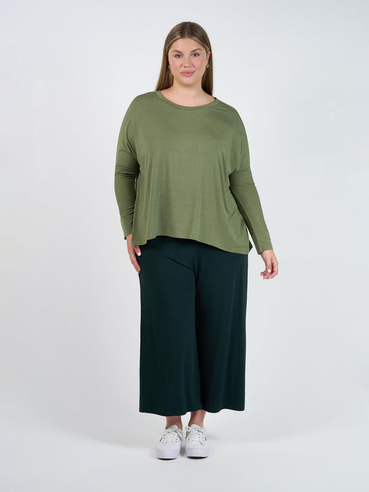 Image of a model wearing Tops. Product name - Gina Long Sleeved Bamboo Top Olive in Olive colour by brand - Lou Lou