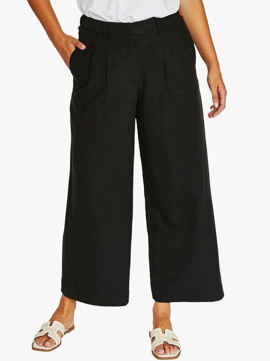 Image of a model wearing Pants. Product name - Jump 7/8 Pleat Front Pant in Black colour by brand - Jump