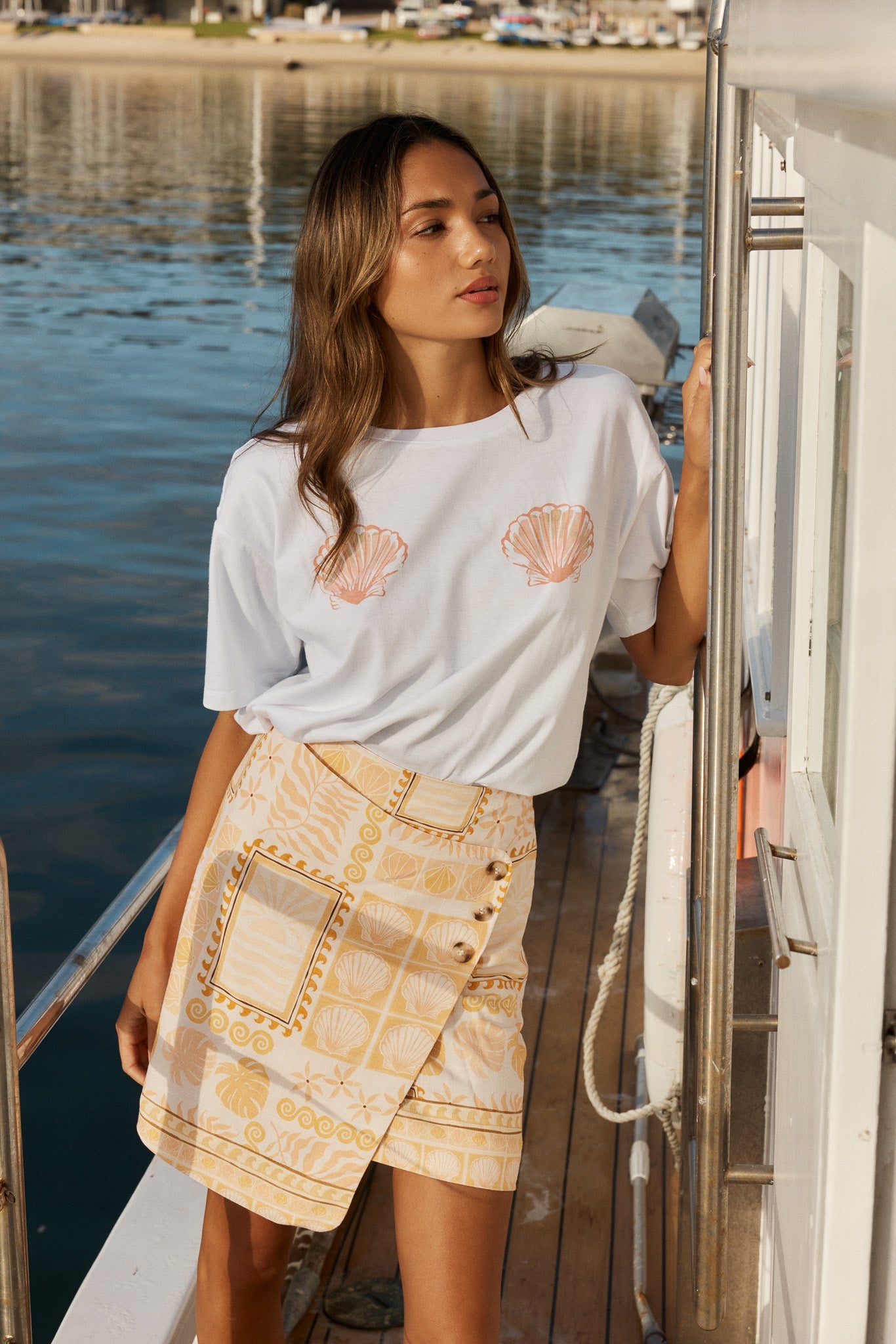Image of a model wearing Skirts. Product name - Coast Mini Wrap Skirt Peach Shell Patchwork in Peach Shell Patchwork colour by brand - Sass Clothing