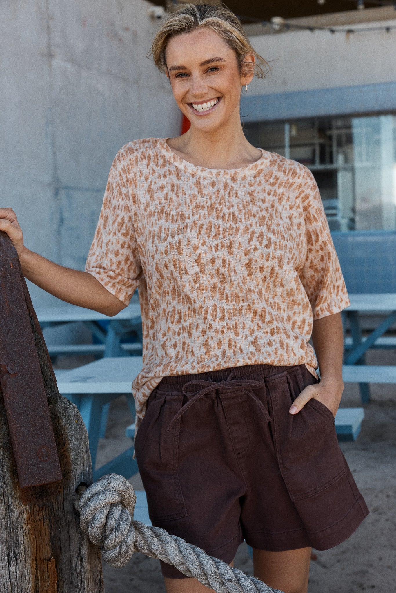 Image of a model wearing Shorts. Product name - Quinn Cotton Short in Chocolate colour by brand - Betty Basics