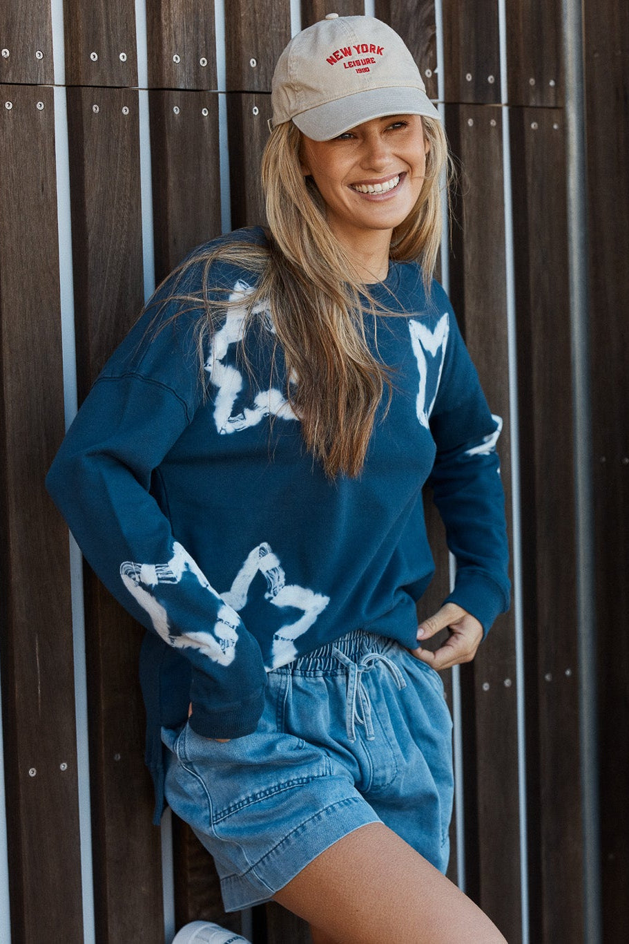 Image of a model wearing Outerwear. Product name - Palma Sweat Navy Star in Navy Stars colour by brand - Betty Basics