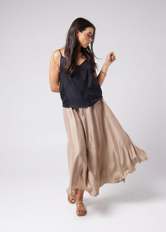 Image of a model wearing Tops. Product name - Clover Sleeveless Silk Cami in Black colour by brand - Lou Lou