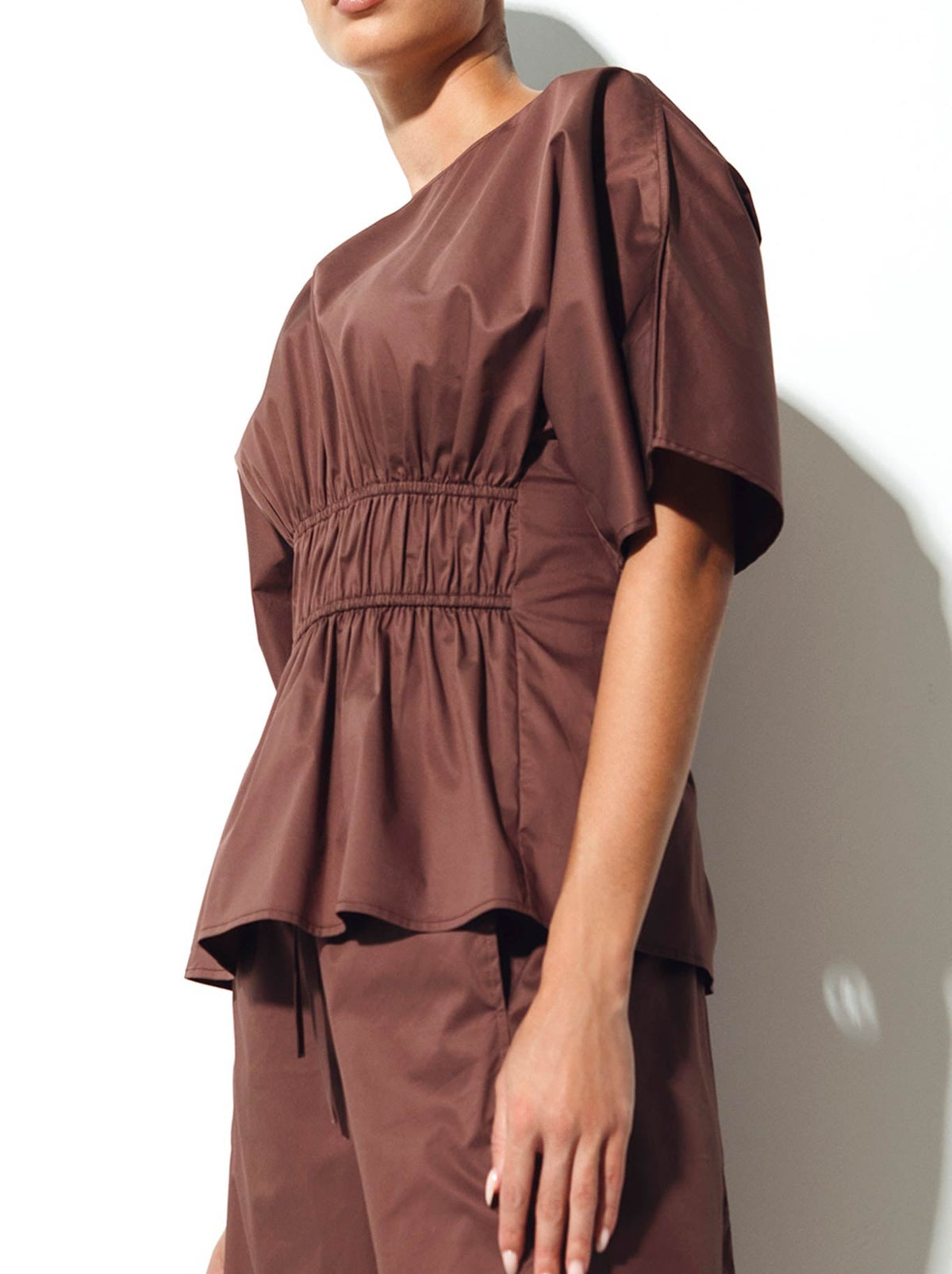 Image of a model wearing Tops. Product name - Lounge The Label Ostuni Top in Fig colour by brand - Lounge