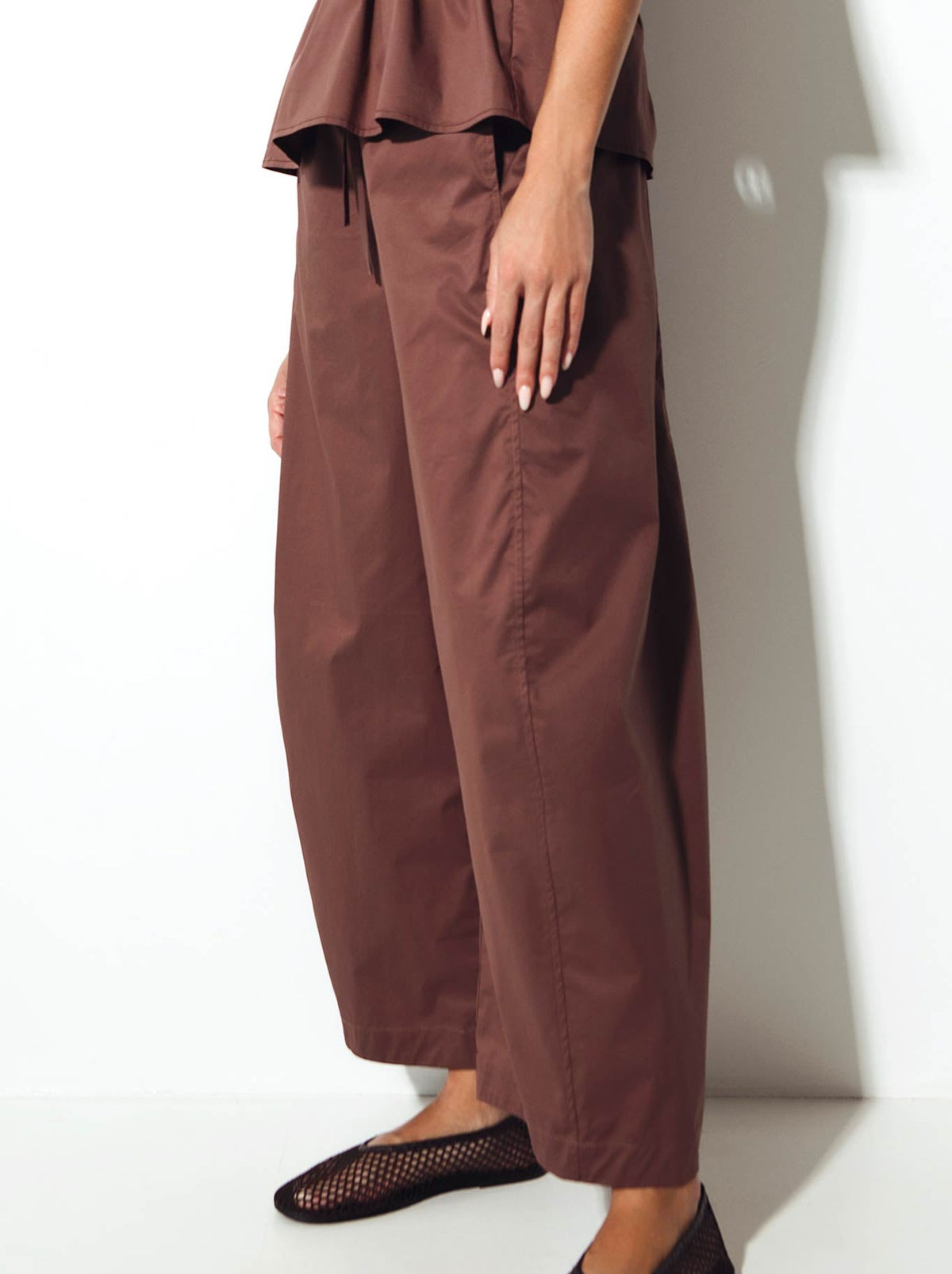 Image of a model wearing Pants. Product name - Lounge The Label Palermo Pant in Fig colour by brand - Lounge