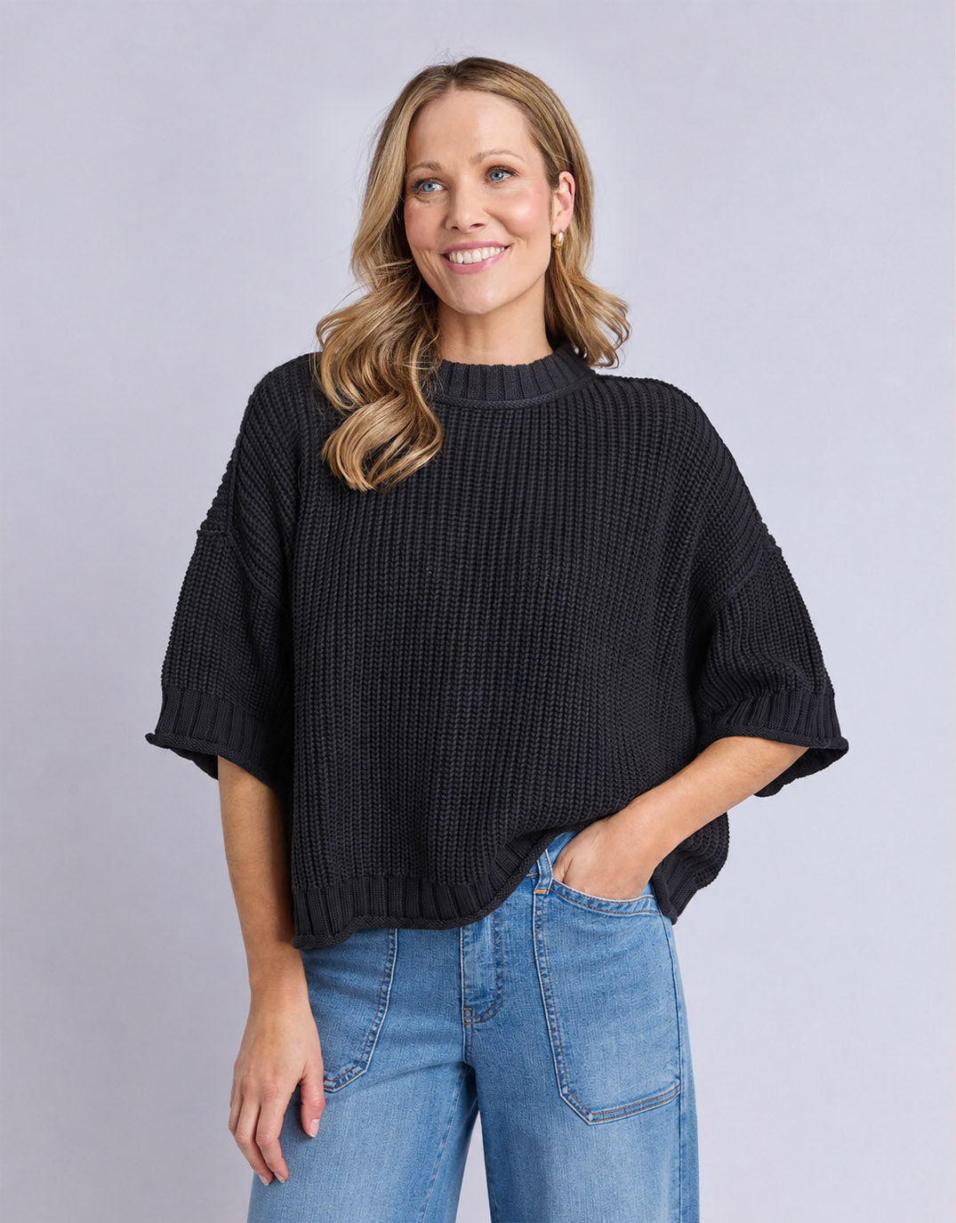 Image of a model wearing Outerwear. Product name - Luela Short Sleeve Knit Black in Black colour by brand - Elm