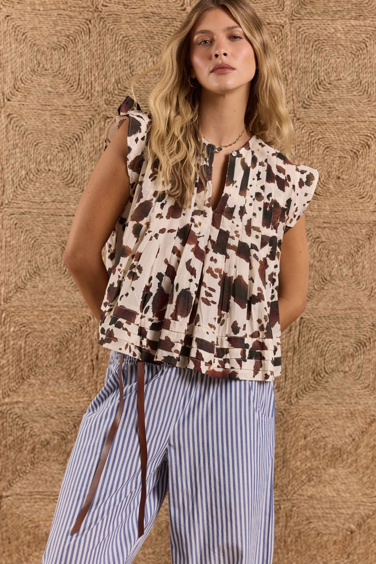Image of a model wearing Tops. Product name - LulaLife Sylvie Top Cow Print in Cow colour by brand - Lulalife