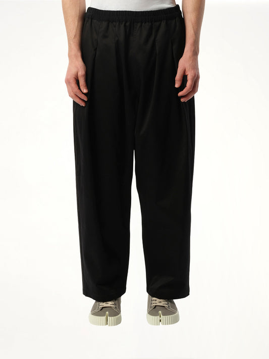 Image of a model wearing Pants. Product name - Stone Washed Relax Chinos in Black colour by brand - MAISON MARGIELA