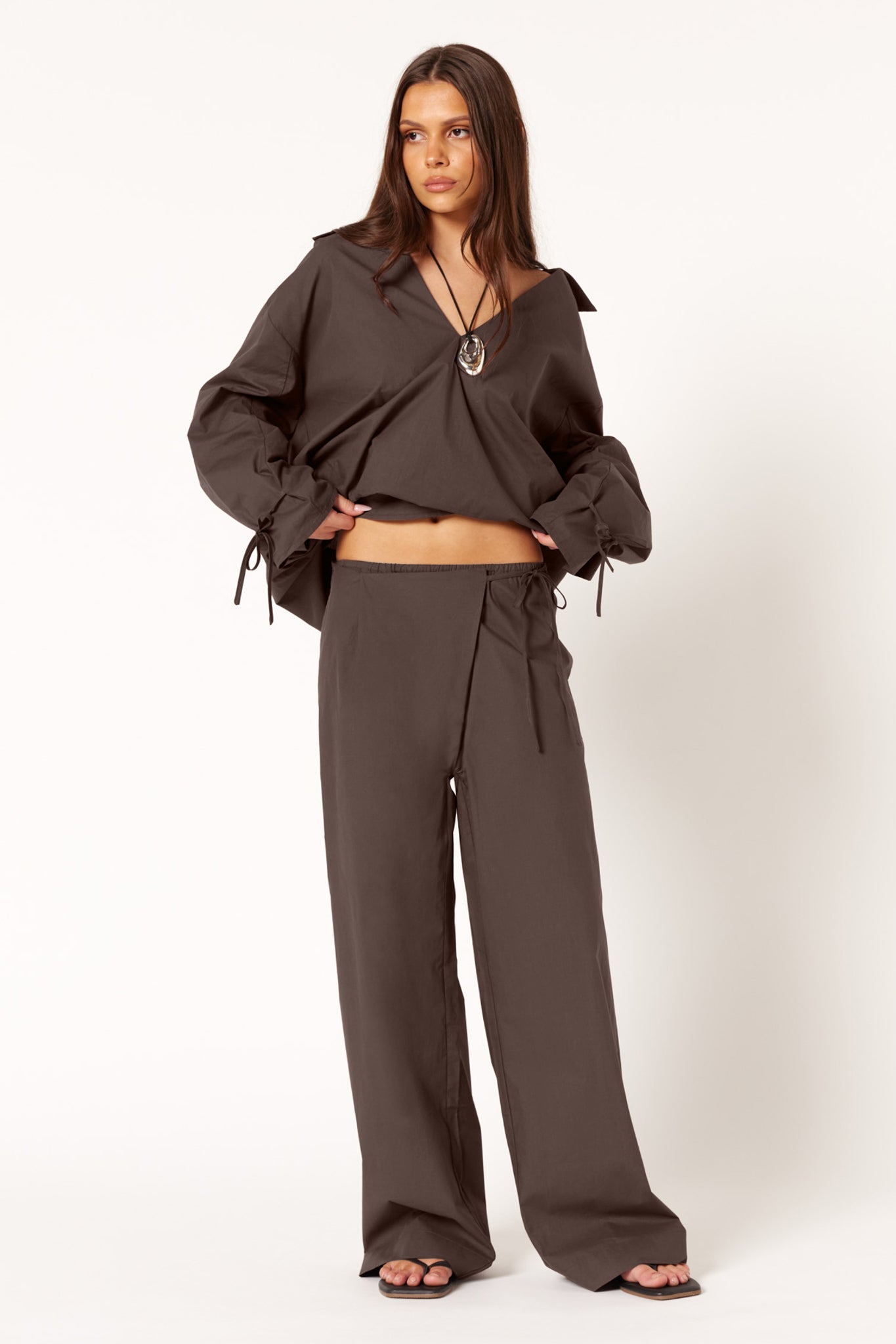 Image of a model wearing Pants. Productname: SNDYS MUSA PANTS in Coffee colour by brand - SNDYS