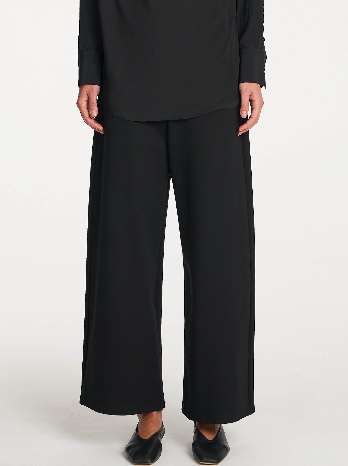 Image of a model wearing Pants. Product name - MELA PURDIE PALAZZO PANT in Black colour by brand - Mela Purdie