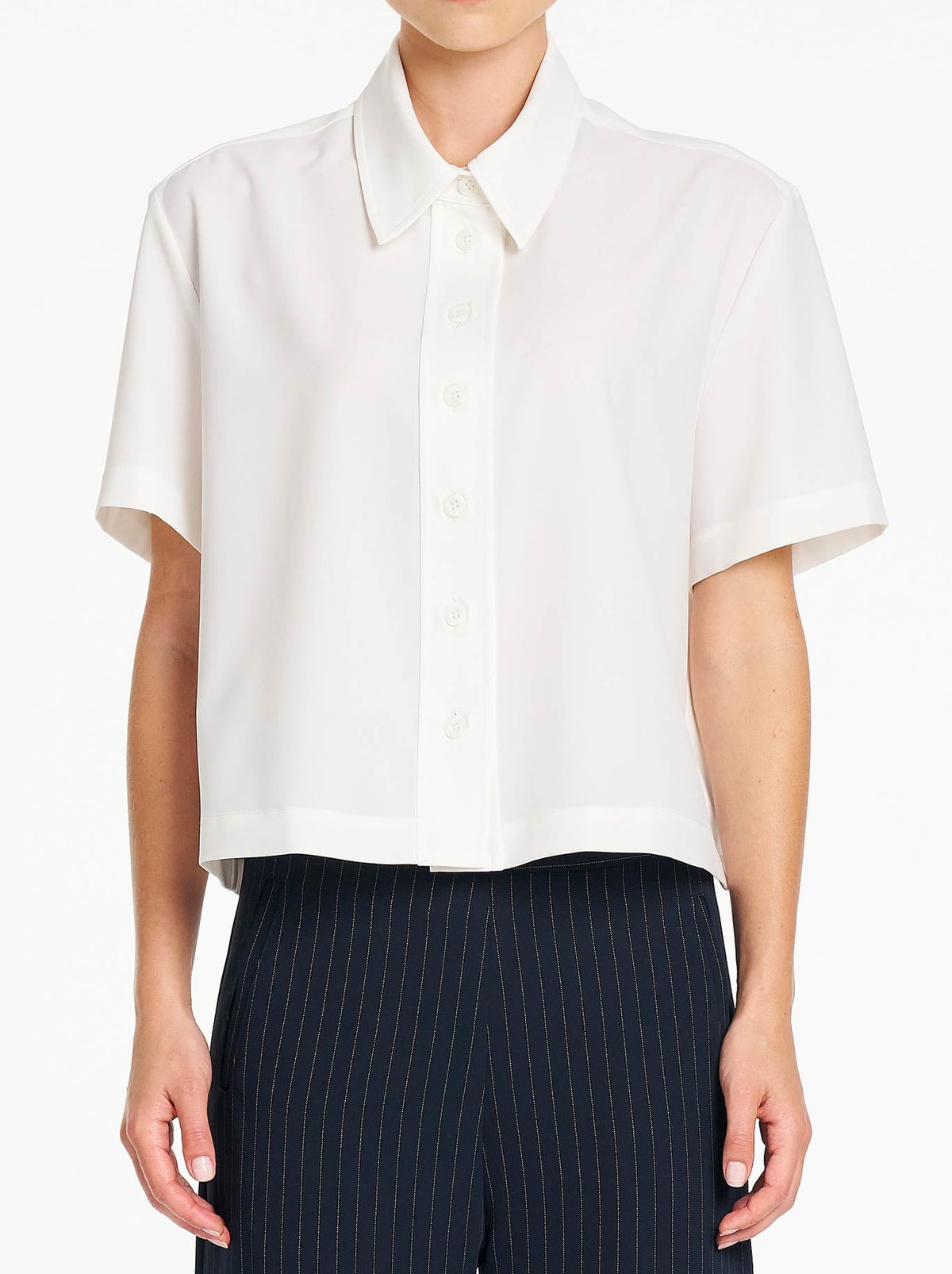 Image of a model wearing Tops. Product name - MELA PURDIE CROP SHIRT in Chalk colour by brand - Mela Purdie