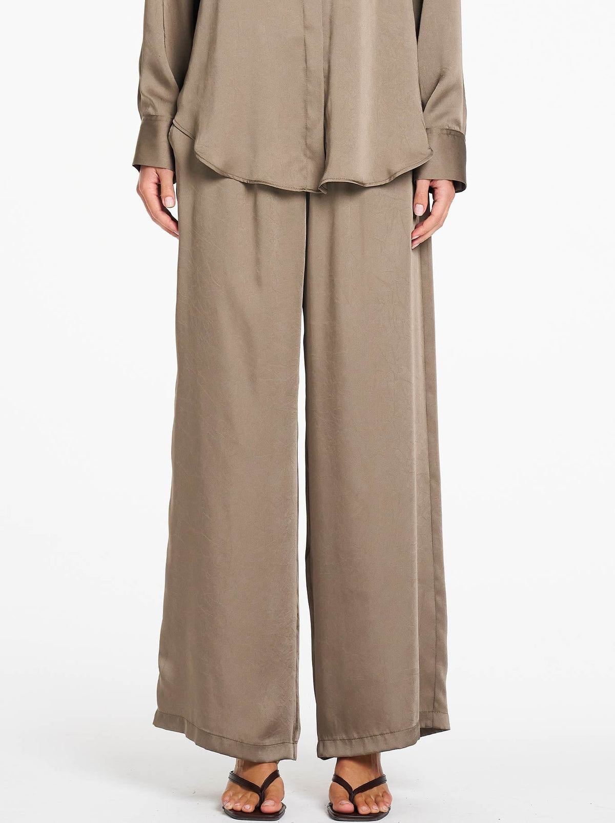Image of a model wearing Pants. Product name - MELA PURDIE MAXI PACE PANT in Twig colour by brand - Mela Purdie