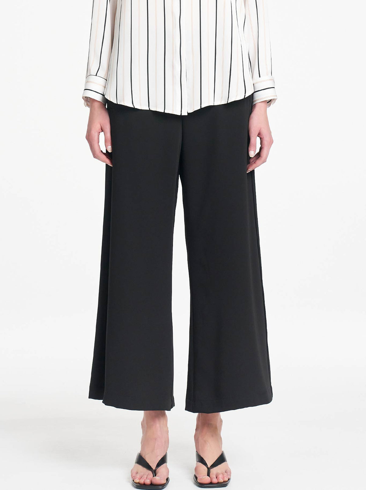 Image of a model wearing Pants. Product name - Mela Purdie Crop Suit Pant in Black colour by brand - Mela Purdie