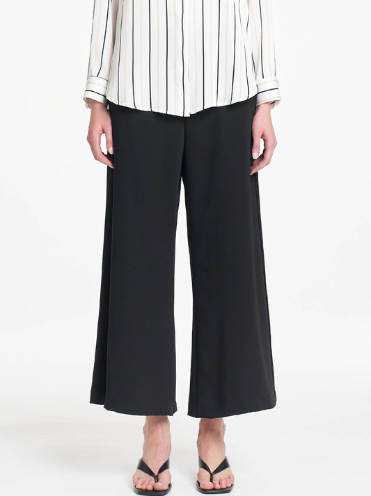 Image of a model wearing Pants. Product name - Mela Purdie Crop Suit Pant in Black colour by brand - Mela Purdie