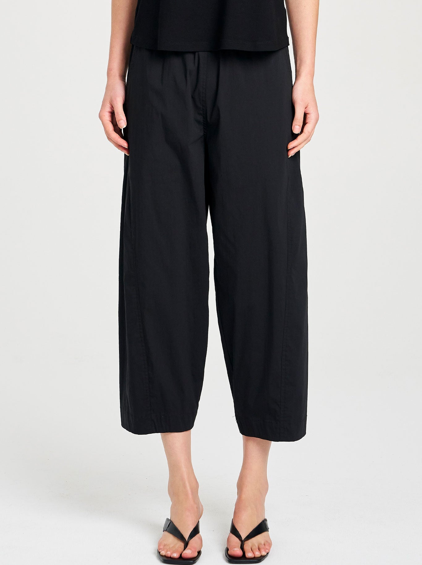 Image of a model wearing Pants. Productname: MELA PURDIE CROSS PANT in Black colour by brand - Mela Purdie