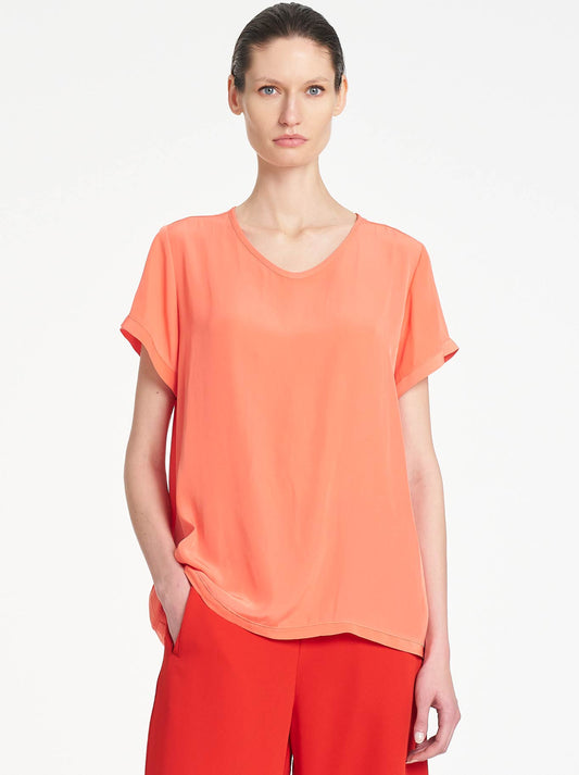 Image of a model wearing Tops. Product name - MELA PURDIE TRAVEL T in Tangerine colour by brand - Mela Purdie