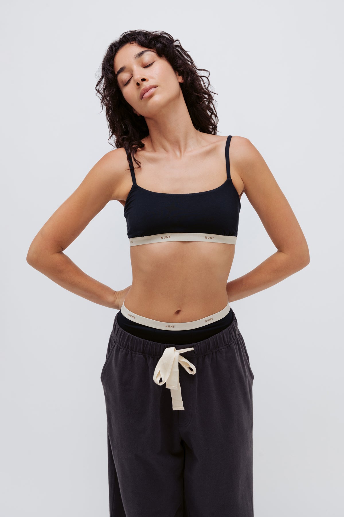 Image of a model wearing Tops. Product name - Square Neck Bralette Black in Black colour by brand - NUNE