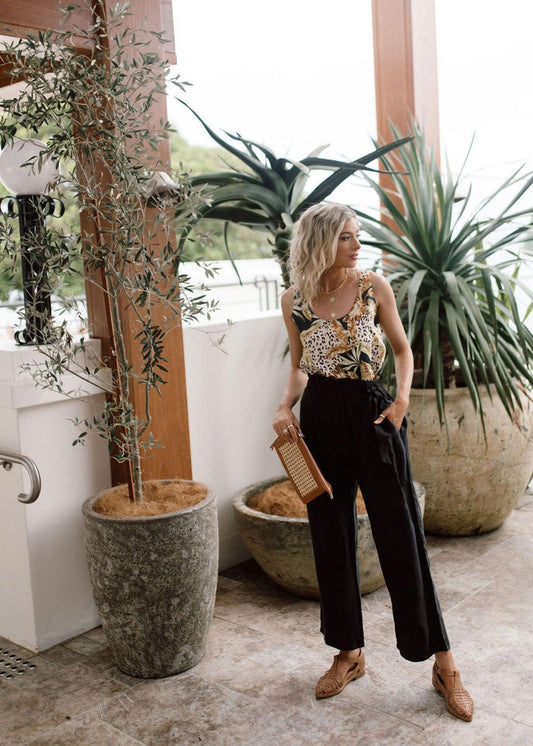 Image of a model wearing Pants. Product name - Marigold Silk Wide-Leg Pants in Black colour by brand - Lou Lou