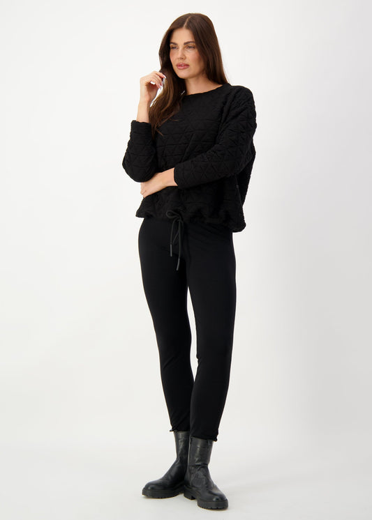 Image of a model wearing Tops. Product name - Sacha Oversized Quilted Bamboo Sweater Black in Black colour by brand - Lou Lou